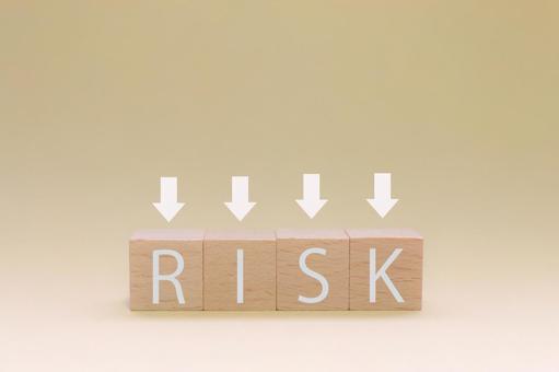 リスク RISKと書かれた積み木ブロックとそれを強調するための矢印