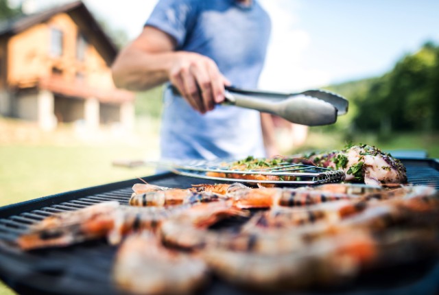 交流会 屋外でバーベキューを楽しむ男性の写真。特定技能外国人との交流会の様子。