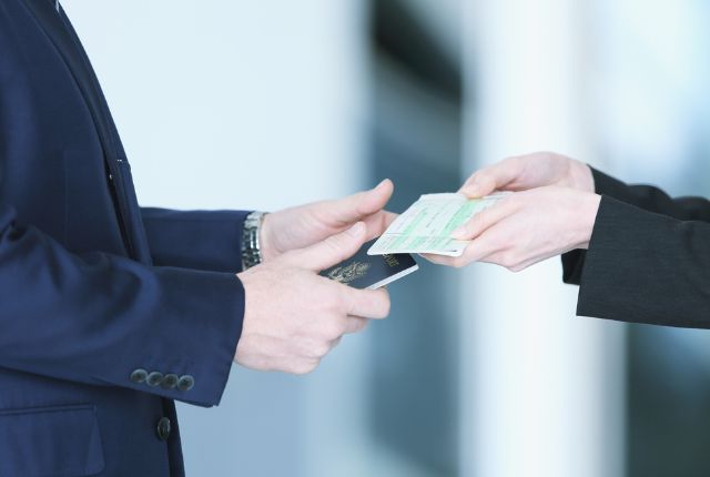 日本への入国 空港でパスポートと搭乗券を手渡す様子。ビザ取得後の日本入国や出国審査の手続きをイメージした場面。