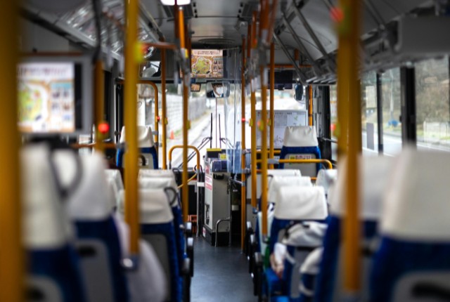 車内から見た路線バスの座席と運転席。公共交通やバス運転手の仕事、乗務環境をイメージさせる写真。