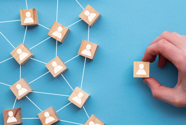 雇用プロセス 人のアイコンが描かれた木製ブロックをつなげるネットワーク構図。外国人材の雇用ネットワークを表すイメージ。