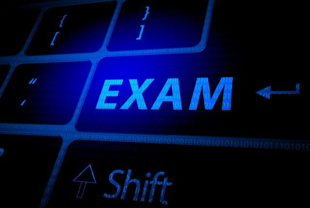 青く光るキーボードのキーに「EXAM」と表示。特定技能試験やオンライン試験をイメージした画像。