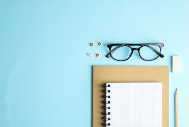 試験対策 眼鏡とノート、鉛筆、消しゴムを並べたデスクのイメージ。試験対策の学習や準備、計画立案のシーン。