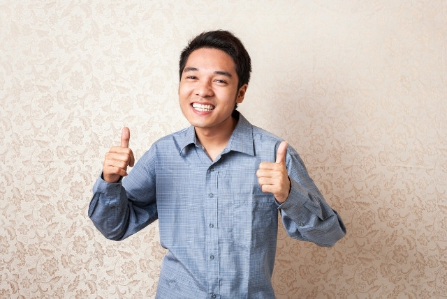 明るく笑顔で親指を立てる男性の姿。フィリピン人材の活躍や職場での前向きな姿勢を象徴するポジティブなイメージ。