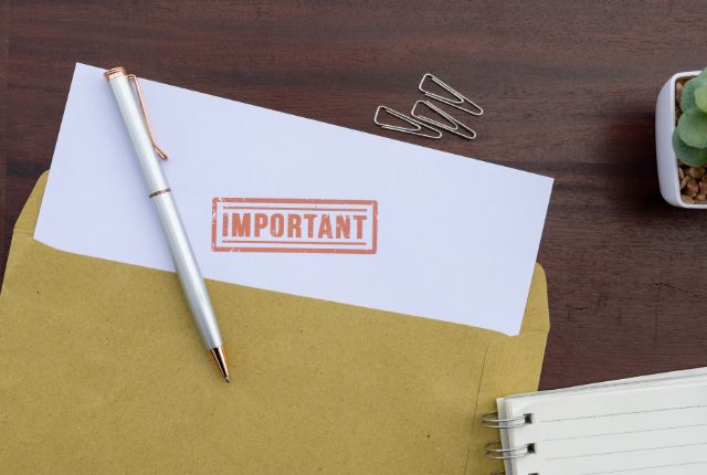 重要書類の手続き 「IMPORTANT」と印字された書類とペン、封筒が置かれたデスク。重要事項や大切な連絡をイメージする写真。