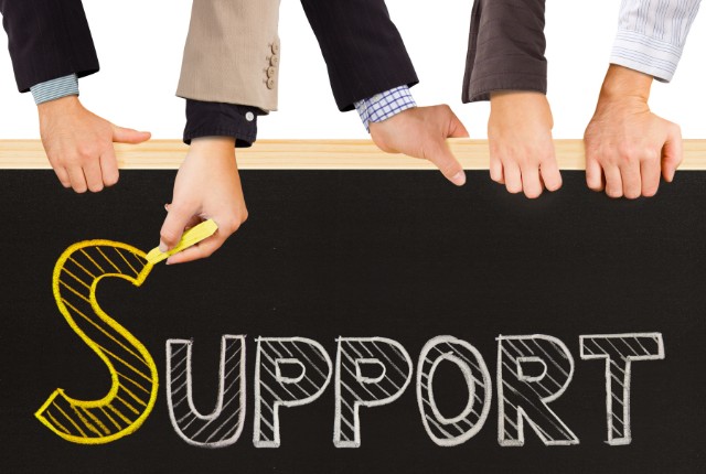 社内の支援体制 「黒板に大きく“SUPPORT”と書かれ、複数の手が支える支援のイメージ。チームワークやサポート体制を表現。