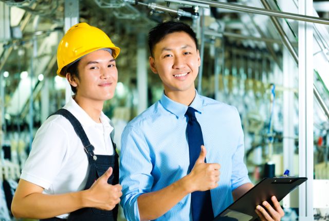 製造工場の特定技能外国人 製造現場で作業員と管理者が親指を立てている様子。特定技能2号の外国人材が活躍する職場のイメージ。