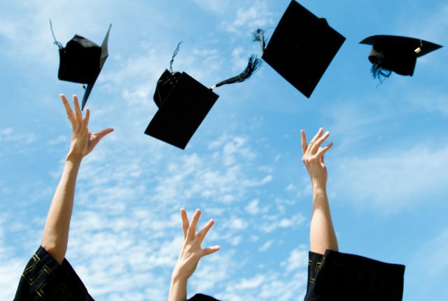 卒業式で学生たちが学位帽を空に投げる様子。新卒外国人採用や留学生の就職・キャリアスタートを象徴するイメージ。