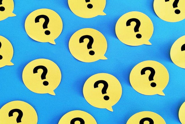 青い背景に並ぶ黄色い吹き出し型の疑問符マーク。技能実習制度や費用・税金に関する疑問を表現した画像。