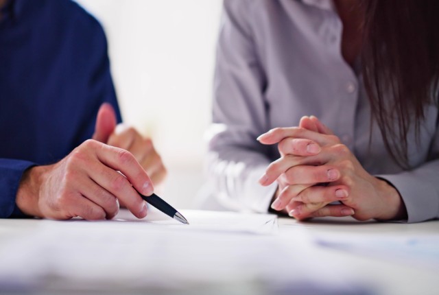 送り出し機関の変更手続きを相談する企業担当者と監理団体の職員が資料を確認しながら打ち合わせをしている様子