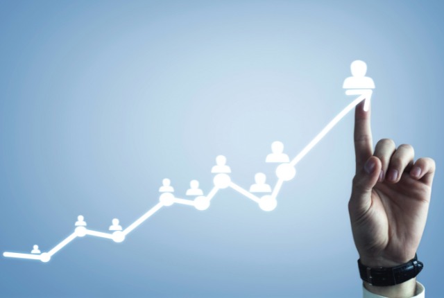 就労ビザの切り替えとキャリアアップ 右手で人材の成長や採用成果を示す上昇グラフを指す様子。人材育成や外国人雇用の成功を象徴する構図。