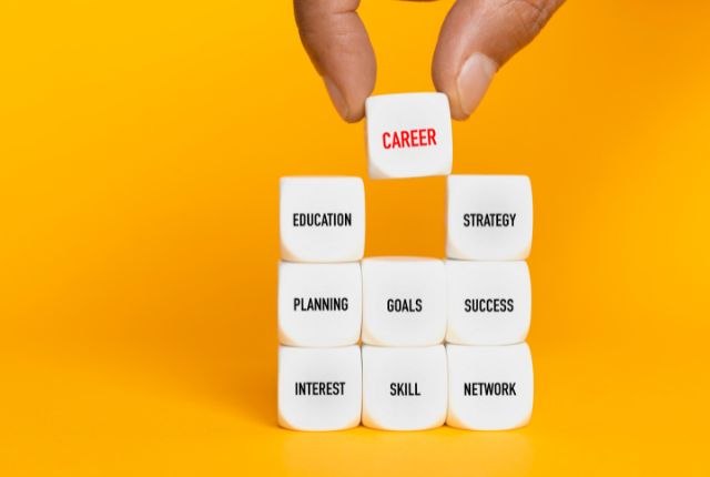 キャリア構築を象徴する積み上げられたブロック。教育・目標・スキル・成功など成長プロセスを表す画像。