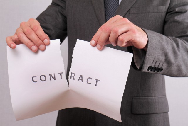契約書を破るスーツ姿の男性。送り出し機関との契約解除や監理団体変更に伴う手続きを象徴する場面