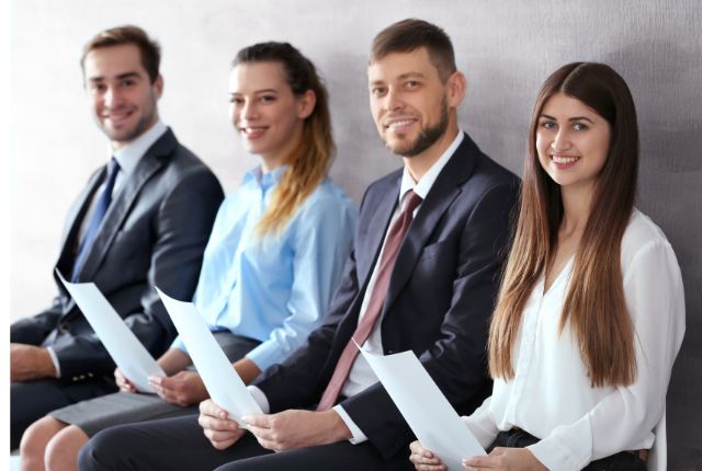 接待ちの応募者が履歴書を持って並んで座る様子、人材採用や選考を表すビジネスイメージ