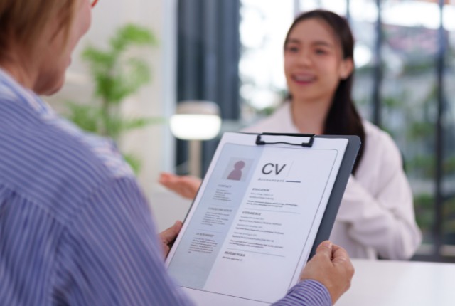 採用面接 履歴書(CV)を確認しながら外国人応募者と面接を行う様子。人材採用や外国人雇用面接の場面を表現。