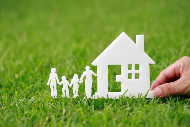 白い家と家族のシルエットを草の上に並べた写真。特定技能2号の家族帯同制度や在留資格申請を象徴的に表現。