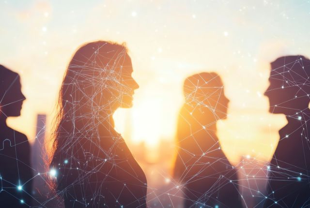 夕日を背景に人物シルエットとネットワーク線が重なる画像。人材ネットワークやグローバル採用を示すイメージ。