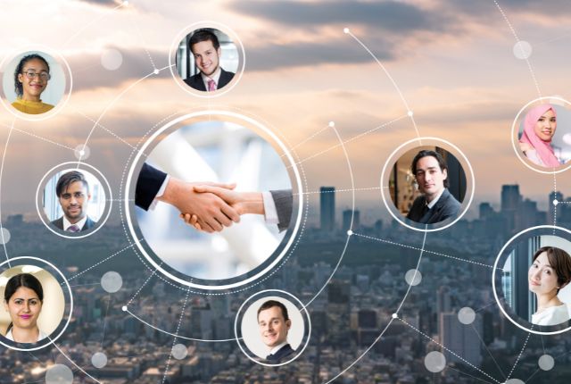 多国籍の人々がネットワークでつながり、中央に握手が映るビジネス連携と国際人材活用のイメージ
