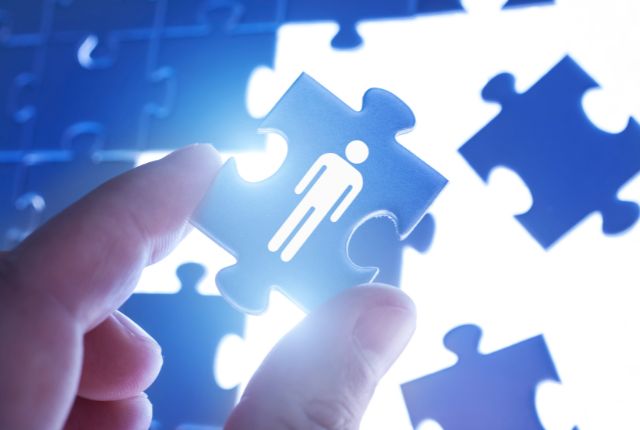 人材配置を象徴するパズルを手で持つ様子。採用や人材マネジメントをイメージしたビジネス写真