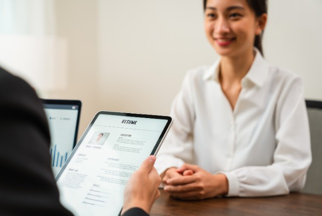面接で履歴書を確認する担当者と応募者の様子。外国人技能実習生の採用面接や選考プロセスを表すイメージ。