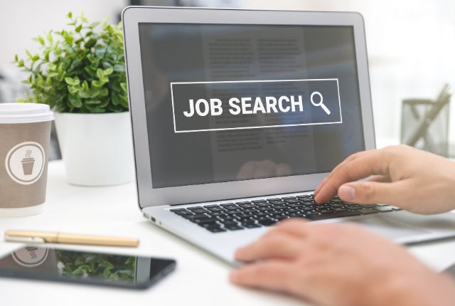 転職サイトの活用 ノートパソコンで求人検索を行う手元の様子。画面に「JOB SEARCH」と表示された転職・就職活動のイメージ写真