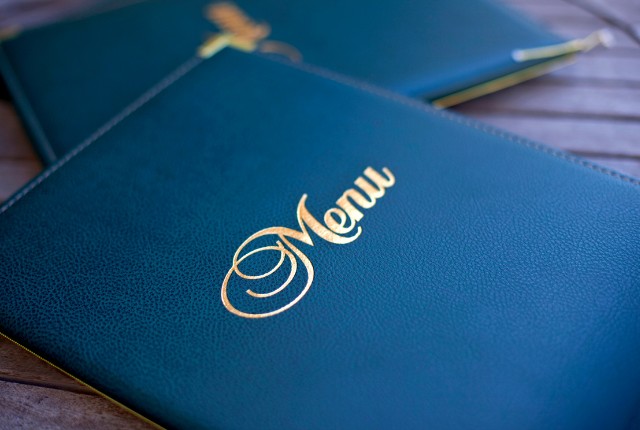 金色の文字で「Menu」と書かれたメニュー表。外食業の接客や店舗運営、特定技能制度の職務内容を象徴するイメージ。