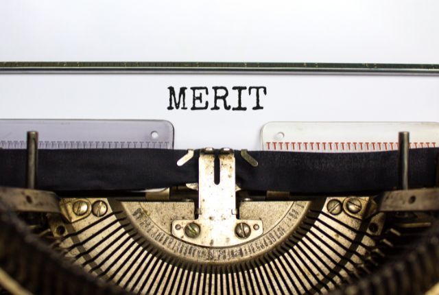 タイプライターで「MERIT」と印字された紙。特定技能2号外国人採用のメリットを示すイメージ。
