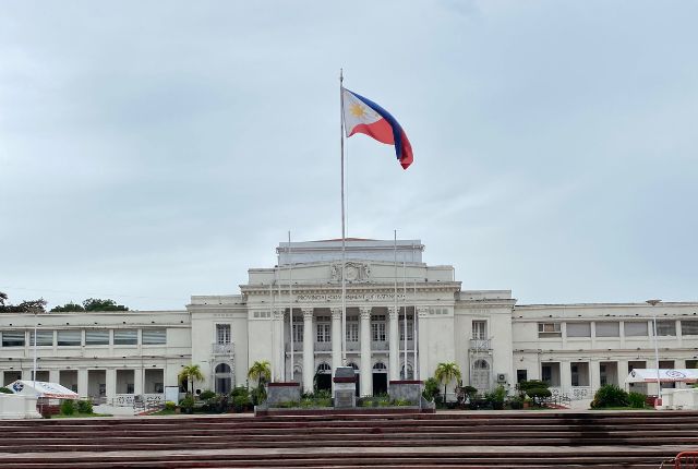 フィリピンの政府施設建物 フィリピン国旗が掲げられた政府関連施設の外観写真。MWO(旧POLO)手続き解説記事用のイメージ。
