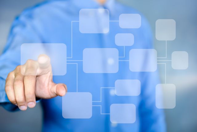 MWO申請の手順 ビジネス手続きや業務フローを示す図を指し示す男性の写真。手続き解説やプロセス説明向けの画像。