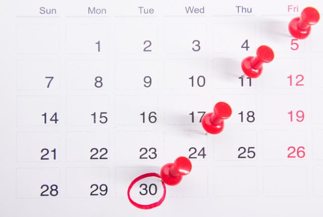 生活オリエンテーションのスケジュールカレンダー カレンダーに複数の赤いピンが刺され、30日が丸で強調されている画像。生活オリエンテーションの日程管理のイメージ。