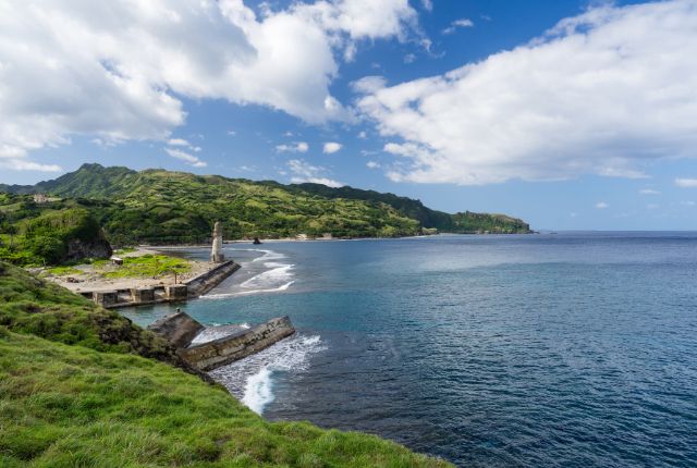 青い海と緑豊かな山々が広がるフィリピンの海岸風景。港と灯台が見える自然豊かな沿岸地域の景色。
