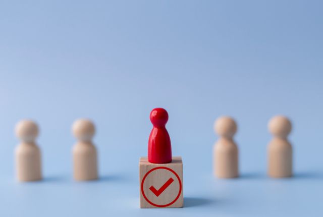 チェックマーク付きの積み木の上に立つ赤い駒。選ばれた登録支援期間をイメージしたビジネス写真。