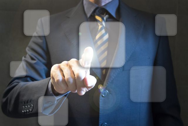 スーツ姿の男性が仮想ボタンをタッチしている画像。外国人材受入れの送り出し機関選定をイメージできる構図