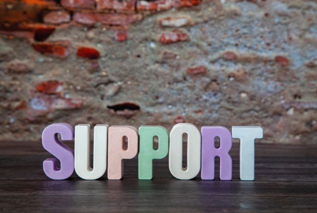 壁の前に並んだ「SUPPORT」の文字ブロック、企業や人材支援を象徴するイメージ写真