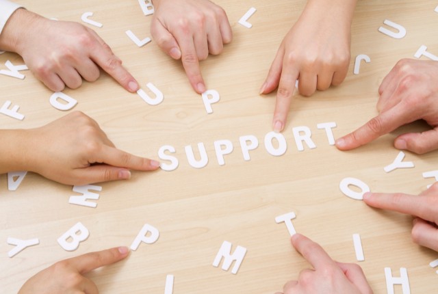 複数の手が「SUPPORT」の文字を指さす様子。外国人技能実習生の支援体制や受け入れ機関のサポートを象徴。