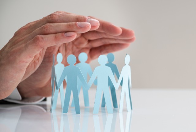 フィリピン人労働者の保護 MWO申請を解説する記事用画像。フィリピン政府がフィリピン人材を守るイメージとして、手で保護された紙の人形が並んでいる様子。