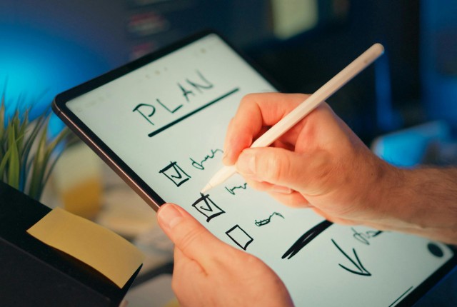 支援計画のドラフト作成 タブレットで支援計画をチェックする手元の様子。特定技能外国人の支援計画作成のイメージ。