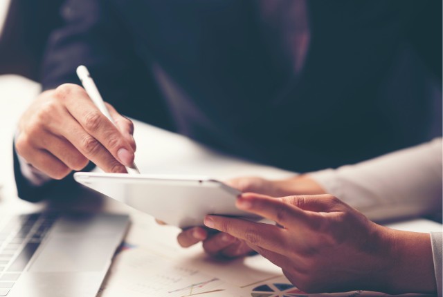 登録支援機関との打ち合わせ タブレット画面を指しながら話し合う手元の写真。特定技能外国人の支援計画や業務相談のイメージ。